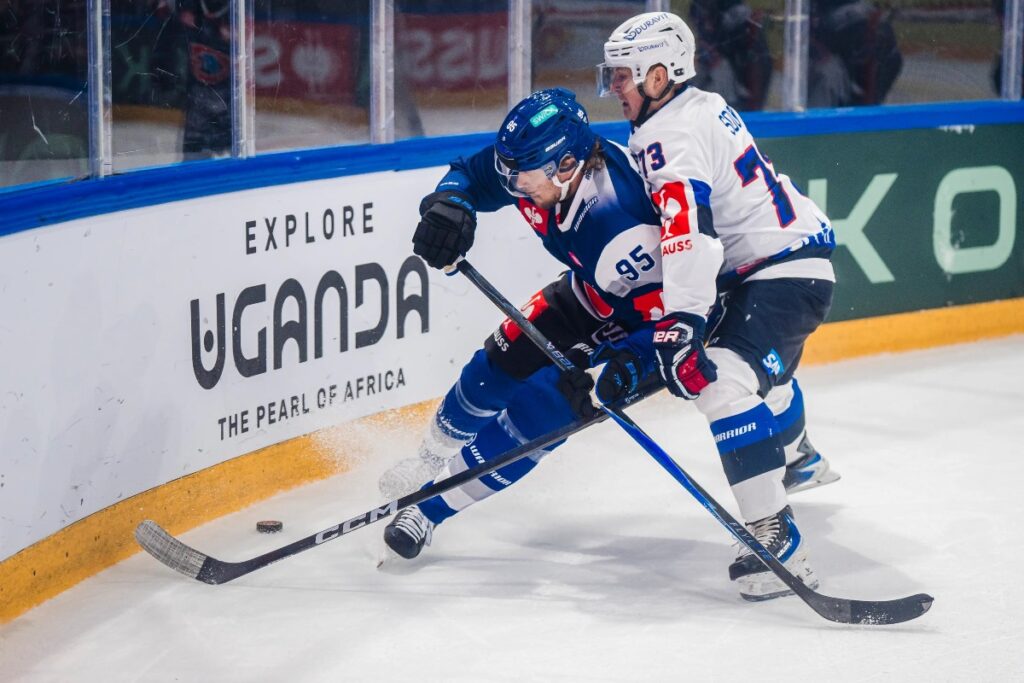 Champions Hockey League action unfolds against the backdrop of Uganda Tourism Board branding, highlighting the one-year strategic partnership designed to introduce Swiss ice hockey audiences to the Pearl of Africa